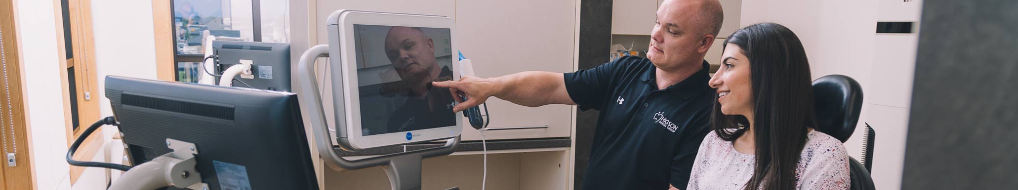 Dr Higson pointing to cosmetic dental image of patient's teeth