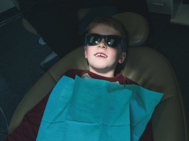 child sitting in dentist chair in Grand Prairie, AB, Canada